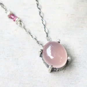 Oval cabochon rose quartz necklace in silver bezel and prongs setting with pink multi-sapphire beads secondary on oxidized silver chain