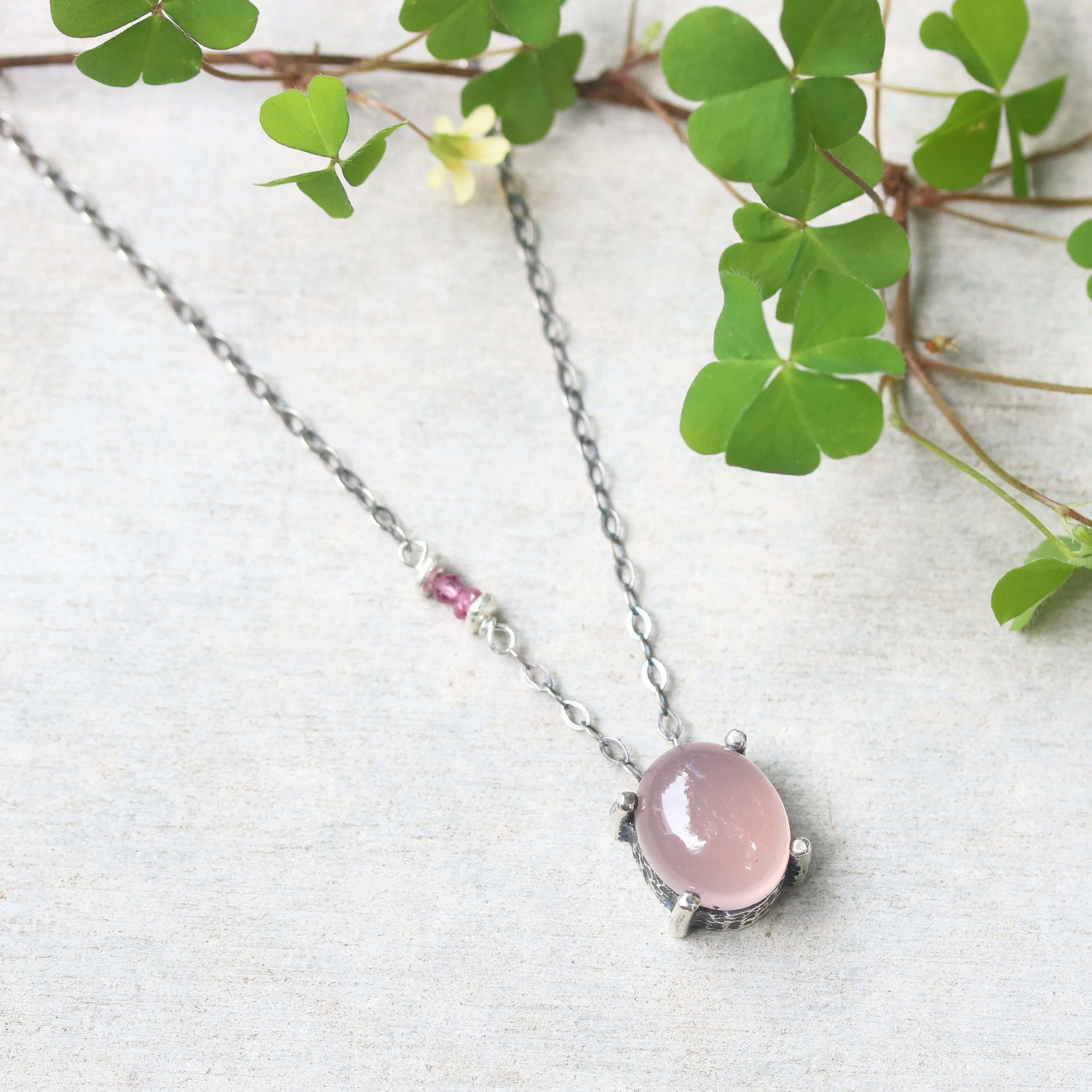 Oval cabochon rose quartz necklace in silver bezel and prongs setting with pink multi-sapphire beads secondary on oxidized silver chain