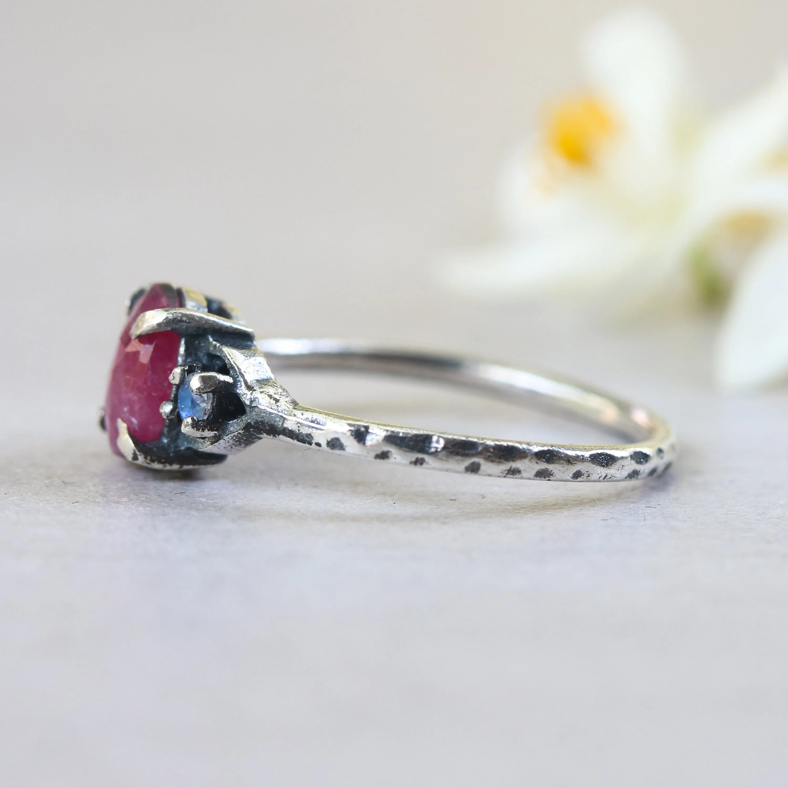 Oval ruby ring with tiny round faceted moonstone side set gems in prongs setting
