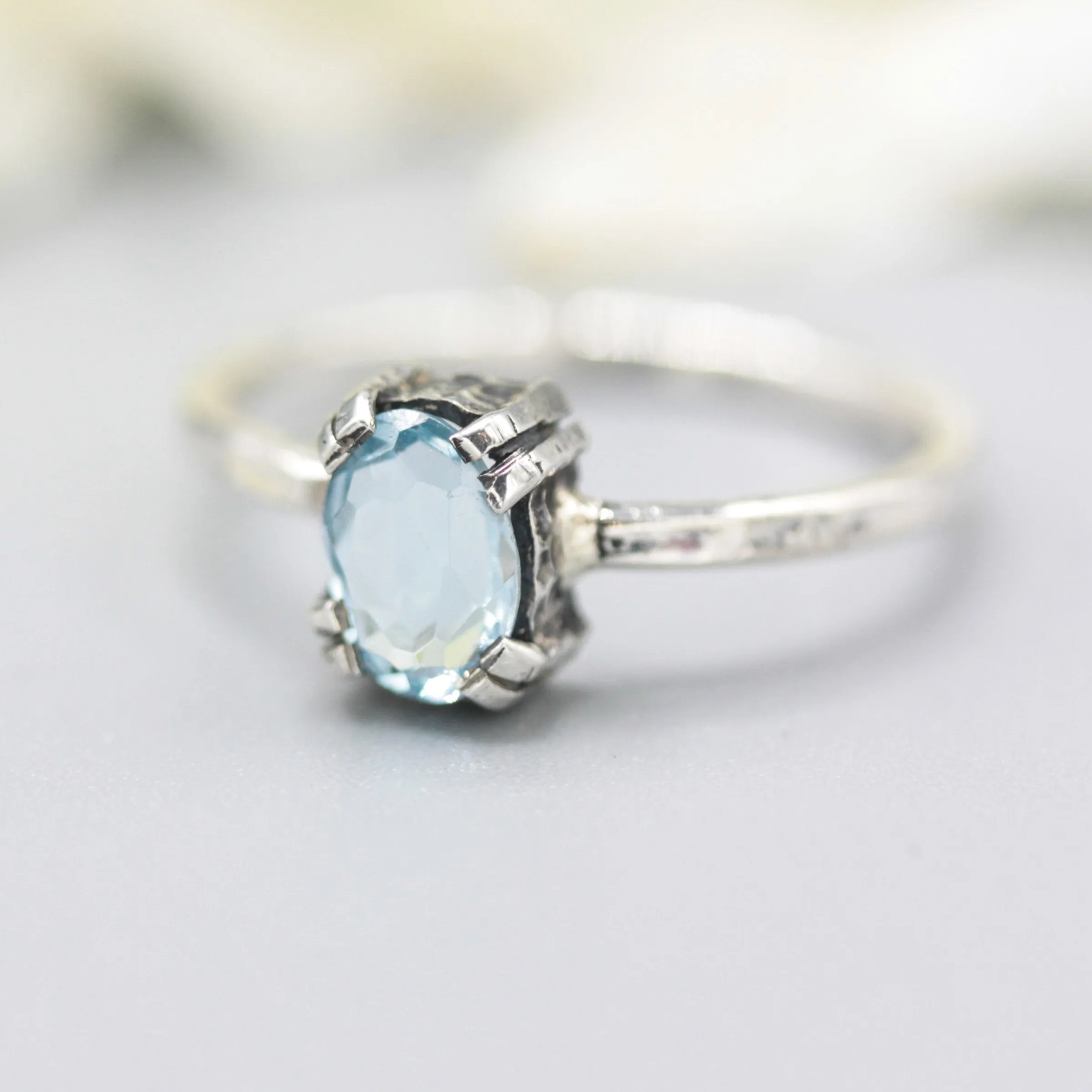 Oval Swiss blue topaz ring in silver bezel and prongs setting with sterling silver band