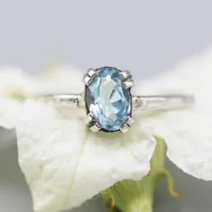 Oval Swiss blue topaz ring in silver bezel and prongs setting with sterling silver band