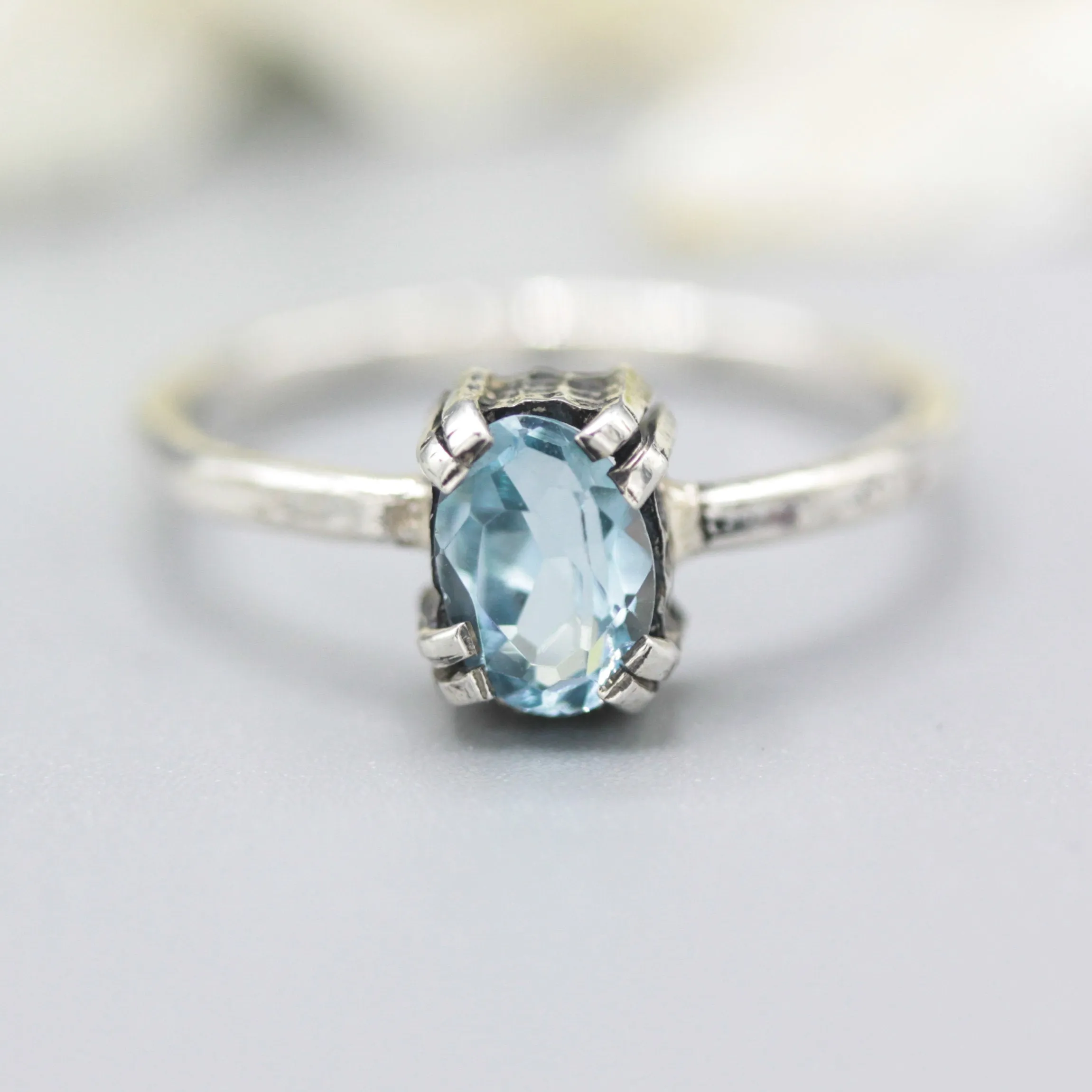 Oval Swiss blue topaz ring in silver bezel and prongs setting with sterling silver band
