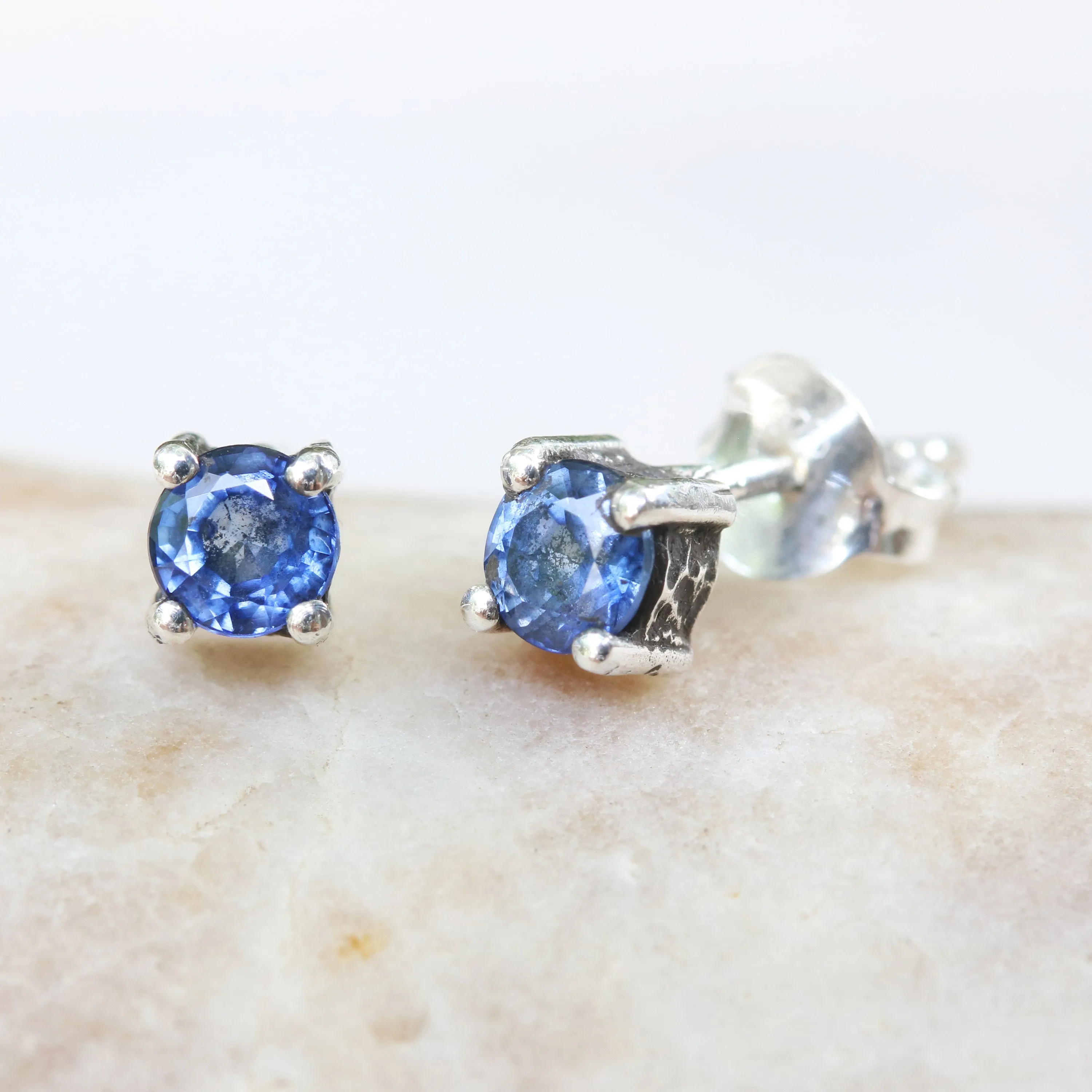 Sterling silver stud earrings with faceted blue sapphire in prongs setting with sterling silver post and backing
